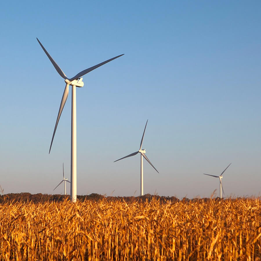 field with blue sky and wind power